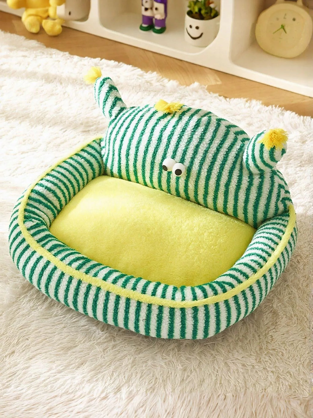 Green and yellow striped pet bed on a white surface